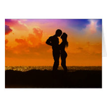 Amants embrassant au coucher du soleil sur la plag cartes de vœux