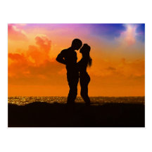 Amants embrassant au coucher du soleil sur la plag carte postale