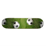Ballon de football dans l'herbe plateau de skate