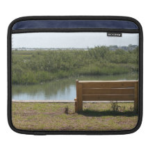 Banc par la rivière avec de l'eau l'herbe et housses iPad
