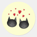 Chats noirs mignons avec des coeurs, sur la crème autocollants ronds