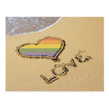 Coeur gai d'amour d'arc-en-ciel dans le sable carte postale