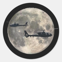 deux hélicoptères silhouettés par une pleine lune adhésif rond