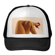 Les jambes nues croisées de la femme avec les talo casquette de camionneur