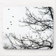 Oiseaux noirs et blancs volant outre des arbres Mo Tapis De Souris
