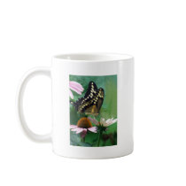 Papillon géant de machaon sur des fleurs tasses