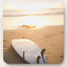 Planche de surf s'étendant sur la plage au coucher sous-bocks