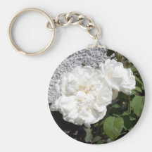 Rose blanc contre un mur à tiret de caillou porte-clefs