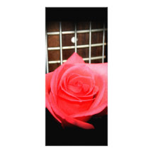 Rose rouge de rose contre le fretboard de cinq con cartes doubles