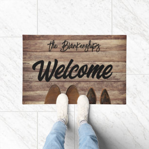 2 paires de bottes sur tapis de porte en bois rust