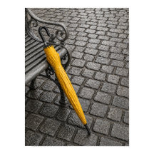 Parapluie jaune fermé à côté d'un banc de parc