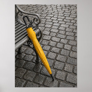 Affiche Parapluie jaune fermé à côté d'un banc de parc