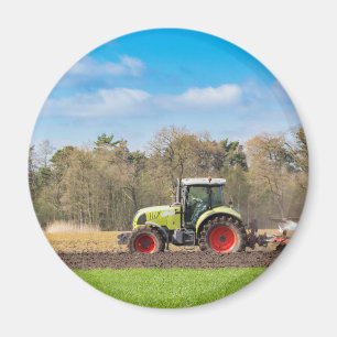 Aimant Agriculteur sur le tracteur labourant le sol