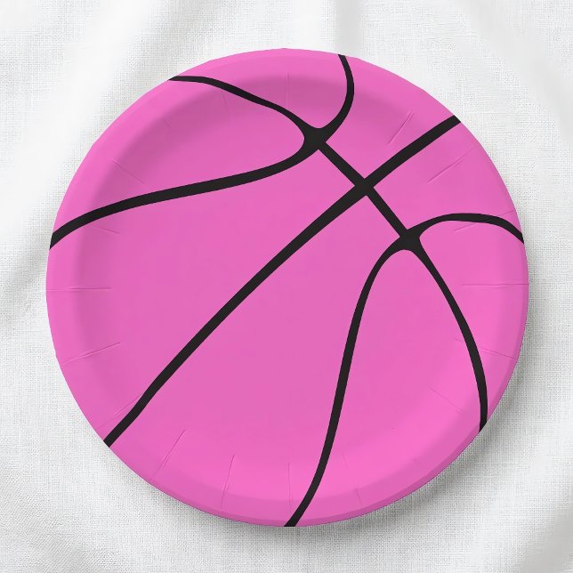Assiettes en papier rose pour basket-ball (Pink basketball paper plates for basketball parties and celebrations, on a white tablecloth.)