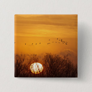 Badge Carré 5 Cm Grues du Canada silhouettées sur le soleil levant