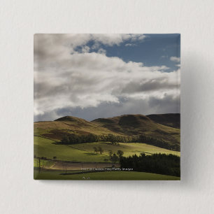 Badge Carré 5 Cm Un paysage avec Rolling Hills et nuages aériens