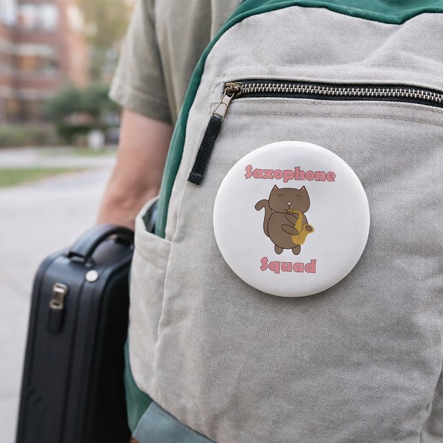 Badge Rond 5 Cm Équipe de saxophone Mignon Chat Kawaii Rose (A pin featuring a brown cat playing saxophone and the words saxophone squad in pink.)