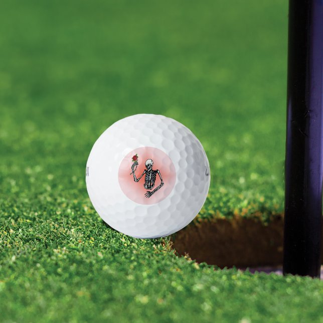 Balles De Golf Gothic Skeleton Single Red Rose (Skeleton holding single red rose on stem on pink background on golf balls.)