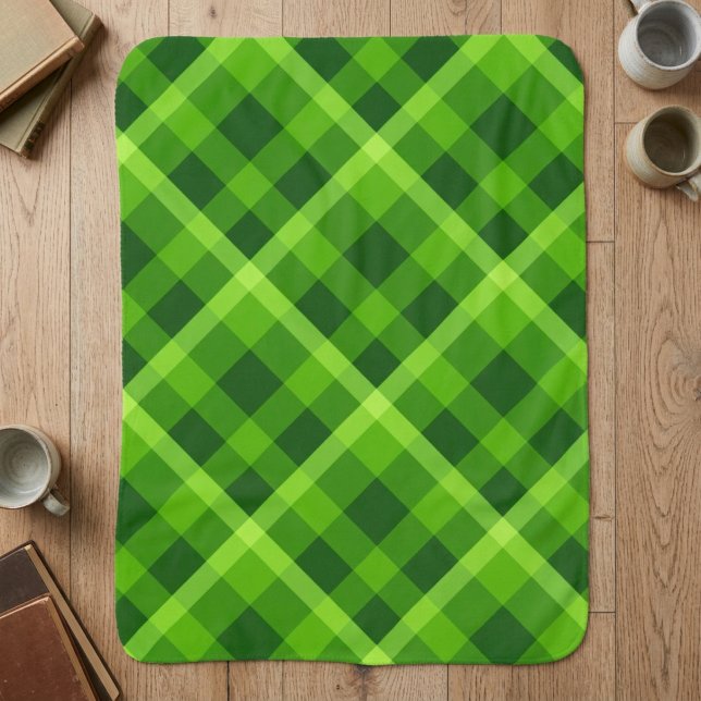 Belle couverture sherpa petite carreaux vert arbre (Top down view of Beautiful Tree Green Plaid Small Sherpa Blanket on a wooden floor in a home.)