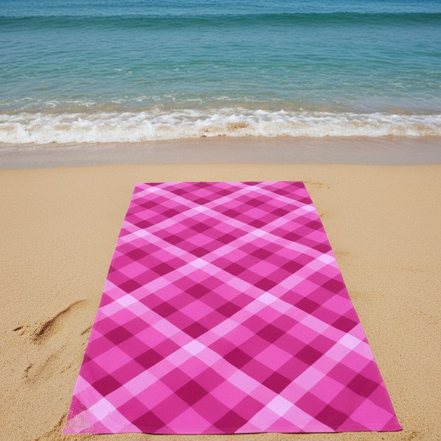 Belle serviette de plage à carreaux rose magenta (Beautiful Pink Magenta Plaid Beach Towel on sand on a beach by the ocean.)