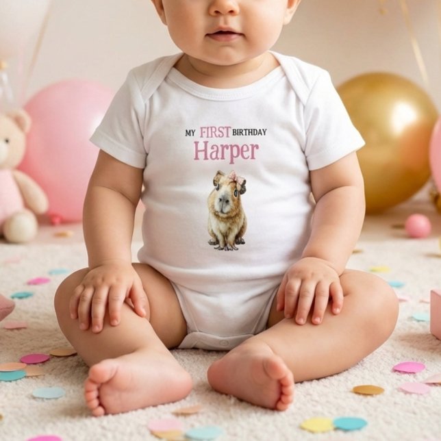 Body Capybara First Birthday • Birthday Outfit (baby wearing white bodysuit with cute capybara and pink first birthday name print on soft floor)