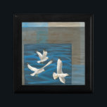 Boîte À Souvenirs Trois mouettes blanches volent au-dessus de l'eau<br><div class="desc">Faut-il s'en aller ? Faites-le en choisissant ce tableau de l'artiste Tara Friel représentant trois mouettes volant au-dessus de l'eau. La vue des vagues de l'océan et les couleurs vives rendent ce design très réaliste.</div>