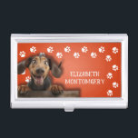 Boîtier Pour Cartes De Visite Empreintes de pattes de Dog Walker<br><div class="desc">Ce porte-carte de visite,  personnalisé avec votre nom,  présente un Dachshund mignon sur orange vif avec une bordure empreinte de patte blanche. Amusez-vous comme un cadeau ou une excellente façon de porter vos propres cartes de visite.</div>
