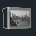 Boucle De Ceinture Rectangulaire Kansas City Urban Skyline, photo noir et blanc<br><div class="desc">À Kansas City, Missouri, la rue Main à six voies s'étend du coin inférieur droit de la photo en noir et blanc vers l'horizon brumeux du gratte-ciel au loin. Une berline sombre, en bas et à gauche du centre, conduit perpendiculairement aux voies de circulation, créant un moment d'intrigue dans le...</div>
