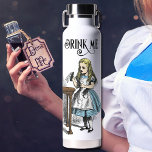 Bouteille D'eau Alice au pays des merveilles Boire moi couleur Ill<br><div class="desc">Alice amusante au pays des merveilles "Buvez-moi" Bouteille d'eau. Le dessin vintage d'Alice portant la bouteille marquée "Buvez-moi" est une copie de l'illustration de John Tenniel de la première édition du livre de Lewis Carroll publié en 1865. Les deux côtés de la bouteille sont imprimés Cette bouteille d'eau isolée en...</div>