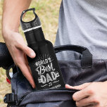 Bouteille D'eau Bonne Fête des pères Amusants World's Best Papa Ki<br><div class="desc">Un cadeau amusant et personnalisé pour le meilleur papa du monde. Le design comprend un design de typographie amusant "Meilleur Père du Monde" et est personnalisé avec le nom de votre enfant et l'année de naissance de votre père. Fait le cadeau parfait pour votre père spécial pour la Fête des...</div>