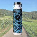 Bouteille D'eau Cercles bleus modernes et tendance sur monogramme<br><div class="desc">Cette bouteille d'eau présente un design moderne avec des cercles bleus sur un arrière - plan noir. Art numérique. Parfait pour toute activité de plein air,  aussi une jolie idée cadeau à toute occasion! Vous pouvez modifier ou supprimer le monogramme,  ainsi que l'arrière - plan du monogramme.</div>