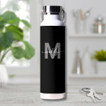 Bouteille D'eau Monogramme de nom moderne noir blanc<br><div class="desc">Créez votre propre bouteille d'eau personnalisée avec monogramme moderne en noir et blanc. Cette bouteille d'eau mignonne et élégante présente un fond noir épuré avec une initiale grise audacieuse, surmontée d'un nom en écriture cursive blanche qui coule pour un effet personnel sur les deux côtés. Idéale pour les étudiants, les...</div>