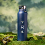 Bouteille D'eau Monogramme en gras sur bleu<br><div class="desc">Le monogramme vertical blanc gras sur le bleu présente une initiale plus grande au centre. Remplacez les 3 initiales par les vôtres dans la barre latérale. Autres couleurs et styles de bouteilles d'eau disponibles dans la barre latérale. Copyright © Claire E. Skinner. Tous droits réservés.</div>