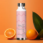 Bouteille D'eau Trendy Chevron Motif grand nom de script pastel<br><div class="desc">Un design audacieux et graphique avec des zags en corail pastel et en zig blanc avec un script écrit main gris amusant pour ajouter votre nom ou n'importe quel texte. Vous pouvez ajouter un nom, un monogramme ou un autre texte personnalisé. Si vous avez besoin de déplacer l'art autour, cliquez...</div>