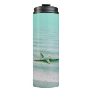 Bouteilles Isothermes Estarfish blanche sur sable sous l'eau le matin