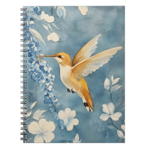 Carnet colibri en vol parmi des fleurs blanches