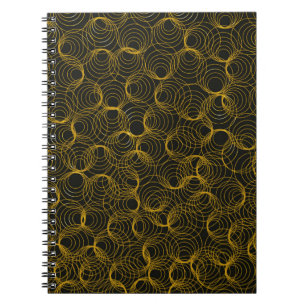 Carnet motif géométrique doré sur un arrière - plan noir.