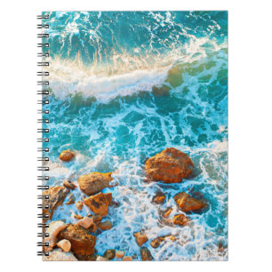 Carnet Vagues sur une plage rocheuse au coucher du soleil