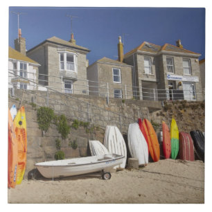 Carreau Kayaks et yoles empilés contre le mur de mer à