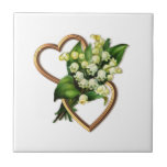 Carreau Le muguet et coeurs<br><div class="desc">Une conception graphique du muguet et de deux a entrelacé des coeurs d'or sur une tuile décorative.  Vous êtes sûrs de trouver beaucoup d'utilisations pour cette belle tuile.  D'autres articles avec la conception sont disponibles.</div>