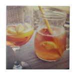 Carreau Sangria and Sunshine<br><div class="desc">This image shows a refreshing glass and pitcher of citrus sangria, perfect for a warm day. The fresh slices of lemon and orange add bright colour and hint of natural sweetness. One glass sits ready to enjoy while sangria is being poured from a small glass pitcher beside it, perfect for...</div>