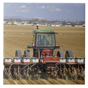 Carreau Tracteur tirant un semoir de maïs semence.
