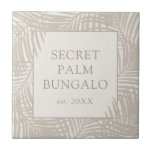 Carreau Tropical Beach House Taupe Palm Motif<br><div class="desc">Un carrelage moderne en feuille de palmier couleur bronze, beige et taupe, avec nom et est de maison de plage personnalisé. date idéale pour une maison de vacances, ou pour décorer une chambre à thème tropical. Le motif à fronde de palme est légèrement abstrait et aléatoire, mais toujours assez symétrique...</div>