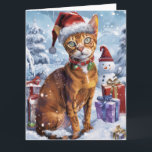 Carte Abyssinian Chat Winter Wonderland Noël Joie<br><div class="desc">Ce design festif reflète l'esprit joyeux de la période des fêtes, avec un adorable petit portant un chapeau de Père Noël. Le chat est niché dans un pays des merveilles hivernales, avec un bonhomme de neige, un sapin de Noël décoré et des cadeaux joliment emballés. Les flocons de neige tombent...</div>