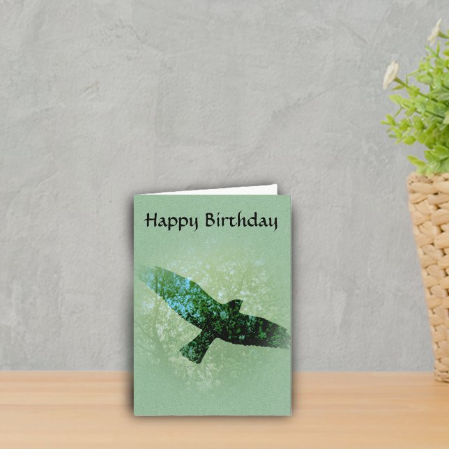 Carte Anniversaire montant de corneille d'oiseau vert (Transparent black crow flying in tree tops on green Happy Birthday greeting card.)