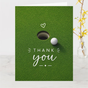 Carte Balle de golf à côté du trou sur de l'herbe verte 
