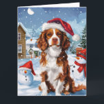 Carte Brittany Spaniel Dog Winter Wonderland Noël<br><div class="desc">Ce design festif reflète l'esprit joyeux de la période des fêtes, avec un adorable petit portant un chapeau de Père Noël. Le chien est niché dans un pays des merveilles hivernales, avec un bonhomme de neige, un sapin de Noël décoré et des cadeaux joliment emballés. Les flocons de neige tombent...</div>