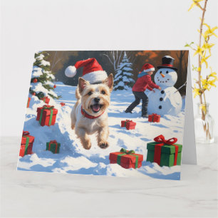 Carte Cairn Terrier courant dans la neige avec un chapea