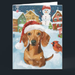 Carte Dachshund Winter Wonderland Christmas Joy<br><div class="desc">Ce design festif reflète l'esprit joyeux de la période des fêtes, avec un adorable petit portant un chapeau de Père Noël. Le chien est niché dans un pays des merveilles hivernales, avec un bonhomme de neige, un sapin de Noël décoré et des cadeaux joliment emballés. Les flocons de neige tombent...</div>