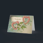Carte d'anniversaire avec les coeurs et le muguet<br><div class="desc">Cette belle carte de voeux a été créée utilisant une carte postale 1900's victorienne antique tôt. Elle comporte les lis blancs de la vallée,  des fleurs roses sous forme de deux coeurs et du message simple "joyeux anniversaire." Ajoutez votre propre message sur l'intérieur,  ou laissez-le vide. Vous décidez !</div>